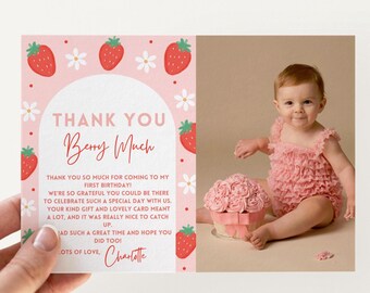 Può includere: Un biglietto di ringraziamento rosa per il compleanno con illustrazioni di fragole e fiori, tenuto accanto a un bambino in un completo rosa con volant. Il biglietto dice "THANK YOU Berry Much" e include un messaggio da Charlotte.