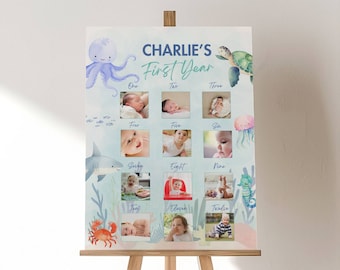 May include: A blue and white first year photo collage with a sea theme. The collage features a baby's photos from each month of their first year. The collage is titled "Charlie's First Year" and features images of an octopus, a turtle, a shark, a crab, a seahorse, and a jellyfish.