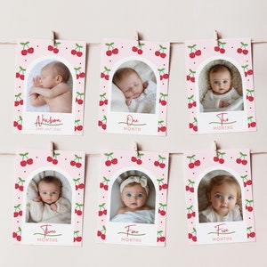 Peut inclure: Six cartes photo roses et blanches avec un motif de cerises. Chaque carte présente une photo d'un bébé à différents âges, du nouveau-né à cinq mois. Les cartes sont étiquetées avec l'âge du bébé en mois.