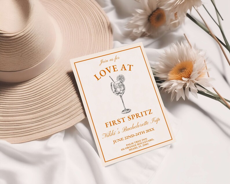 May include: A white card with orange text that reads "Join us for Love At First Spritz Nikki's Bachelorette Trip June 22nd-24th 20XX Palm Tree Inn 456 Orange Boulevard, Miami, FL. 25463". The card has a drawing of a cocktail glass with a lemon slice and a straw.