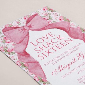 K&ouml;nnte beinhalten: Eine rosa und wei&szlig;e Einladung mit einer gro&szlig;en rosa Schleife und einem Blumenmuster. Der Text lautet "Love Shack Sixteen" und "Bitte feiern Sie mit uns den sechzehnten Geburtstag von Abigail Grace". Datum, Uhrzeit und Adresse sind ebenfalls enthalten.