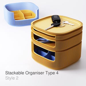 Può includere: Un organizer impilabile giallo e blu. L'organizer ha un design a coste ed è composto da più vassoi. Le chiavi e un portachiavi per auto sono appoggiati sopra. Il testo "Stackable Organiser Type 4 Style 2" è visibile.