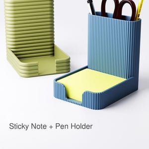 Può includere: Due organizer da scrivania, uno verde e uno blu, con un design a coste. L'organizer verde è un vassoio. L'organizer blu contiene un blocco note adesive giallo, penne, forbici e una matita. Il testo sull'immagine recita "Sticky Note + Pen Holder."
