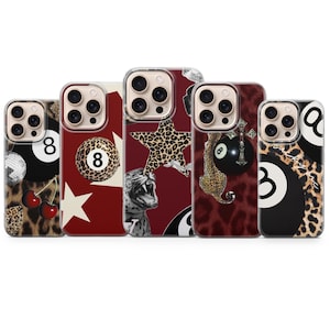 May include: A collection of five phone cases with unique designs. The cases feature a variety of patterns, including leopard print, stars, and billiard balls. Some cases have cherries, a disco ball, and a roaring tiger graphic.