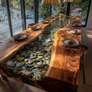Pu&ograve; includere: Un grande tavolo da pranzo su misura con un design unico. Il tavolo presenta una superficie in legno a bordo vivo con un fiume di resina trasparente riempito di pietre lisce. Il tavolo &egrave; apparecchiato con piatti, posate e bicchieri.