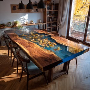 May include: A large, rectangular wooden dining table with a blue resin river running through the center. The table is approximately 10 feet long and features embedded yellow leaves. The table is surrounded by wooden chairs and sits on a hardwood floor.