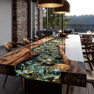 Pu&ograve; includere: Un tavolo da pranzo unico con un design a forma di fiume. Il tavolo presenta un centro in resina trasparente riempito di pietre, incorniciato da un bordo in legno scuro. Sedie in legno circondano il tavolo e la stanza ha un design moderno.