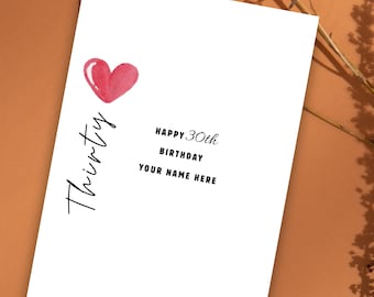 May include: White birthday card with a watercolor-style pink heart and the word "Thirty" in a script font. The card also includes the text "Happy 30th Birthday" and space for a name.