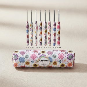 May include: A set of crochet hooks with floral patterned handles and a matching case. The hooks range in size from 2.75mm to 6.0mm. The case has a zipper closure and the text "Crochet for a Happier You!"
