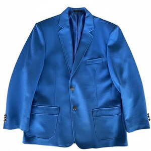 May include: A bright blue blazer with a classic two-button closure, notched lapels, and two front pockets. The jacket has gold-colored buttons and is made of a smooth, possibly satin-like fabric. The blazer is a solid color and appears to be unworn.