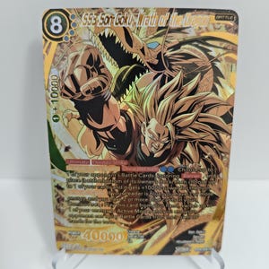 May include: A gold trading card featuring Son Goku from Dragon Ball Z. The card has a detailed illustration of Son Goku and a dragon, with text including "Ultimate Double Strike" and "40000 Power".