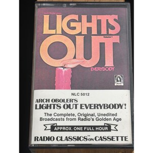 Puede incluir: Una cinta de cassette vintage de "Lights Out Everybody!" de Arch Oboler. La portada presenta el título en naranja y rojo, con una vela rosa y las palabras "Radio Classics on Cassette". La caja de la cinta es negra.