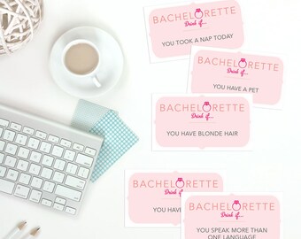 May include: Pink bachelorette party drinking game cards with the text "Bachelorette Drink if..." and various prompts such as "You took a nap today", "You have a pet", "You have blonde hair", and "You speak more than one language".