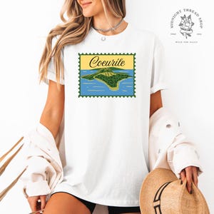 Camiseta oficial con licencia de Coeurile Postage Stamp / Sacred Sea Island / Spark of the Everflame de Penn Cole.