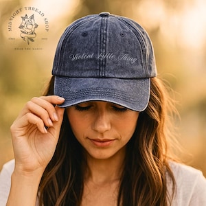 May include: A distressed, faded blue baseball cap featuring the text "Violent Little Thing". The cap has a curved peak and a worn appearance. The Midnight Thread Shop logo is visible in the background.