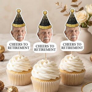May include: Three cupcakes topped with decorative paper toppers featuring a photograph of an elderly person wearing a black and gold glitter party hat. Below the face, a white speech bubble displays the text CHEERS TO RETIREMENT in black.