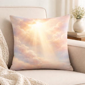 May include: Square decorative pillow featuring a celestial design. The pillow displays a vibrant image of a sunburst breaking through fluffy, pastel-colored clouds. The color palette includes shades of peach, pink, and gold, creating a warm and inviting aesthetic.
