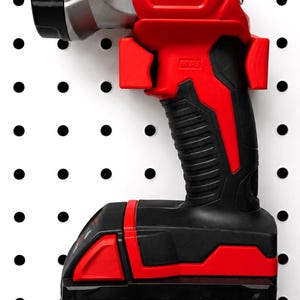 May include: A red and black Milwaukee M18 LED work light with a black handle and battery pack. The light has a silver head and the Milwaukee logo in white. The battery pack is labeled M18 REDLITHIUM XC5.0.