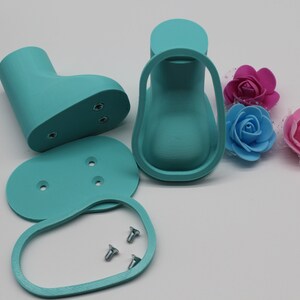May include: A set of turquoise blue plastic doll shoe molds with three screws. The molds are for a doll's shoe, heel, and sole.