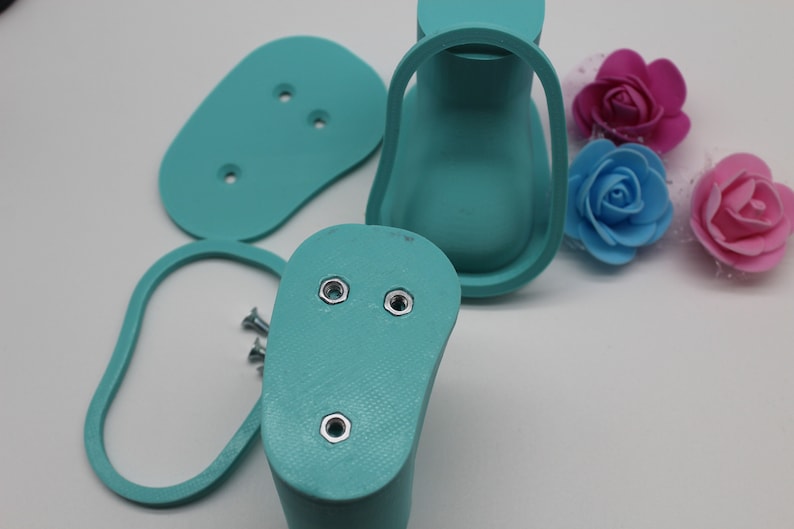 May include: A set of turquoise blue 3D printed shoe molds with screw holes. The molds are for making shoes and are shown on a white surface.