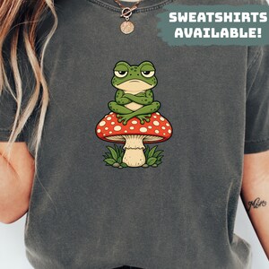 Comfort Colors® T-Shirt mit mürrischem Frosch auf Pilz – Sarkastisches Geschenk für Froschliebhaber – Lustiges Kröten-Shirt – Cottagecore-Shirt für Damen – Niedliches Fliegenpilz-T-Shirt