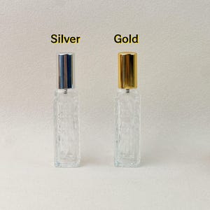 Silver and gold cap 12ml clear diamond-cut glass perfume atomizer bottles, side-by-side view.