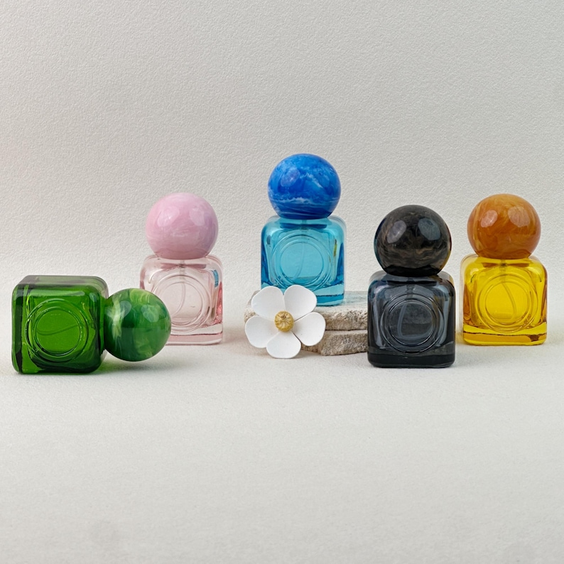 30ml colored glass perfume bottles with marbled caps (pink, blue, gray, yellow, green), multiple arrangements showing all color sets on neutral background.