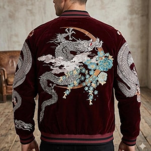 Puede incluir: Una chaqueta bomber de terciopelo color burdeos intenso con un intrincado bordado en la espalda. El diseño muestra un gran dragón plateado que se enrosca alrededor de una luna creciente dorada, con flores azul claro y nubes blancas en las mangas.