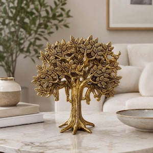 May include: A gold-colored decorative tree sculpture featuring a textured trunk, sprawling branches, and numerous detailed leaves. The sculpture stands upright with a wide, root-like base, showcasing a metallic finish and intricate craftsmanship.