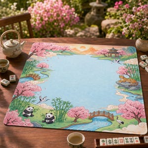 Pode incluir: Um tapete de jogo quadrado com uma ilustração colorida de uma paisagem com cerejeiras, bambu, um rio sinuoso, duas pontes de madeira, um pagode, dois pandas, um leopardo e grous sob um céu ensolarado com montanhas distantes.