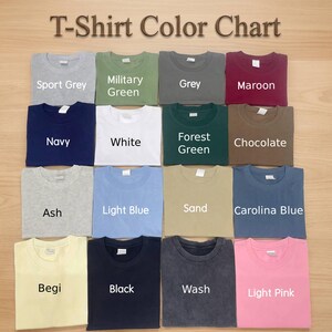 Puede incluir: Una carta de colores de camisetas que muestra diecis&eacute;is camisetas de cuello redondo dobladas en varios colores s&oacute;lidos, incluyendo Sport Grey, Military Green, Grey, Maroon, Navy, White, Forest Green, Chocolate, Ash, Light Blue, Sand, Carolina Blue, Begi, Black, Wash y Light Pink.