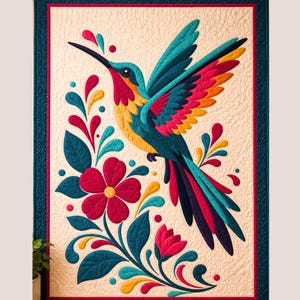 Puede incluir: Un tapiz acolchado rectangular que presenta un colibrí central en vuelo con plumas de color verde azulado, amarillo y magenta. El ave está rodeada de motivos florales estilizados y hojas en colores a juego sobre un fondo crema con un borde oscuro.
