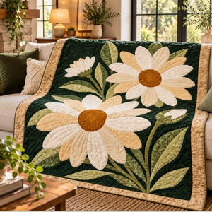 Könnte beinhalten: Eine rechteckige Steppdecke mit dunkelgrünem Hintergrund und großen applizierten Gänseblümchen in Creme- und Hellgelbtönen mit strukturierten braunen Mitten. Die Decke hat einen beigen Rand und durchgehend sichtbare Steppnähte.