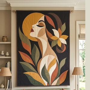 Pode incluir: Uma tapeçaria retangular de tecido com o perfil estilizado de uma pessoa em tons de amarelo mostarda, creme, castanho e verde azeitona. O design inclui formas de folhas grandes e um detalhe floral sobre um fundo preto sólido.
