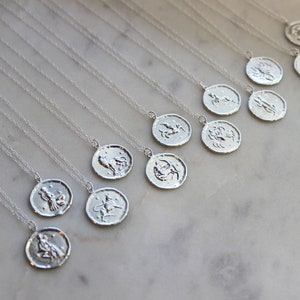 May include: A collection of silver necklaces with zodiac symbols on the pendants. Each pendant features a different zodiac sign, including Aries, Taurus, Gemini, Cancer, Leo, Virgo, Libra, Scorpio, Sagittarius, Capricorn, Aquarius, and Pisces.