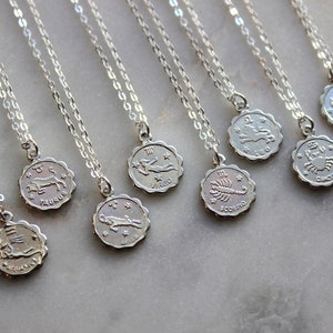 Puede incluir: Un conjunto de collares de plata con colgantes de signos del zod&iacute;aco. Cada colgante presenta un s&iacute;mbolo del zod&iacute;aco diferente, incluyendo Sagitario, Tauro, Virgo, Escorpio, C&aacute;ncer, y m&aacute;s.