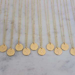 Peut inclure: Colliers dor&eacute;s avec des cha&icirc;nes d&eacute;licates et des pendentifs ronds. Chaque pendentif pr&eacute;sente un motif floral diff&eacute;rent. Les colliers sont pr&eacute;sent&eacute;s sur une surface en marbre blanc, cr&eacute;ant une pr&eacute;sentation &eacute;pur&eacute;e et &eacute;l&eacute;gante.