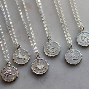 Puede incluir: Un conjunto de collares de plata con colgantes de signos del zod&iacute;aco. Los colgantes presentan los s&iacute;mbolos astrol&oacute;gicos de Leo, Escorpio, C&aacute;ncer, G&eacute;minis, Capricornio, Libra y Piscis.