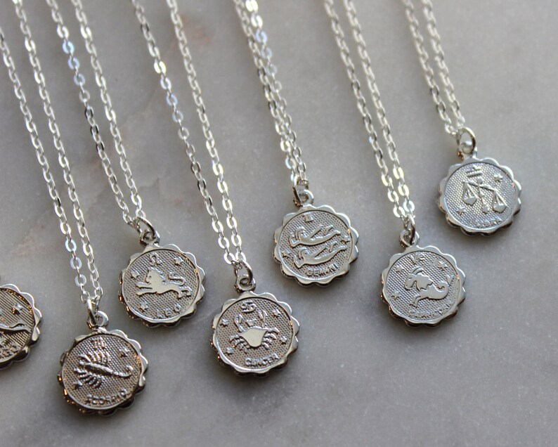 Puede incluir: Un conjunto de collares de plata con colgantes de signos del zod&iacute;aco. Los colgantes presentan los s&iacute;mbolos astrol&oacute;gicos de Leo, Escorpio, C&aacute;ncer, G&eacute;minis, Capricornio, Libra y Piscis.