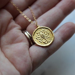 Pu&ograve; includere: Collana d'oro con un ciondolo rotondo che presenta un designo di scorpione dettagliato. Il ciondolo &egrave; testurizzato e ha un design in rilievo.