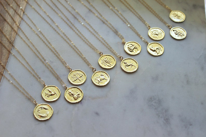 Pu&ograve; includere: Un set di 12 collane d'oro con ciondoli a forma di segni zodiacali. Ogni ciondolo presenta un segno zodiacale diverso, tra cui Ariete, Toro, Gemelli, Cancro, Leone, Vergine, Bilancia, Scorpione, Sagittario, Capricorno, Acquario e Pesci.