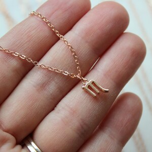 May include: A delicate gold chain necklace with a small, detailed Scorpio zodiac sign pendant.