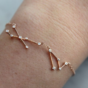 May include: A delicate gold bracelet with a constellation design featuring small clear stones.