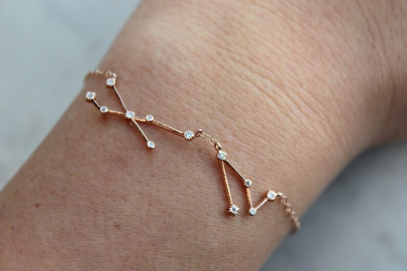 May include: A delicate gold bracelet with a constellation design featuring small clear stones.