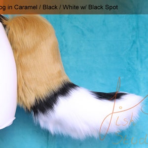 A luxury faux fur wild dog themed fursuit tail.

The base of the tail is caramel, tip is white. A black band seperates the two colours. There is also a black spot on the top of the white section. 

Great fur cosplays and costumes