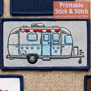 Peut inclure: Écusson brodé représentant une caravane vintage. La caravane est blanche avec des accents bleus, notamment des étoiles et des encadrements de fenêtres. L'auvent est rouge et blanc. L'écusson est bordé d'un cadre bleu marine. Le texte sur l'écusson indique "Printable Stick & Stitch".