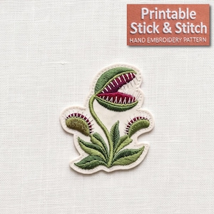 May include: An embroidered patch featuring a Venus flytrap plant with green leaves and a central trap with a deep red interior and white teeth. The text "Printable Stick & Stitch HAND EMBROIDERY PATTERN" is displayed in a brown box at the top right.