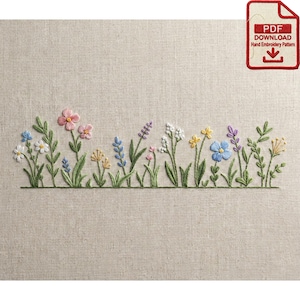 May include: Hand-embroidered floral design featuring a variety of colorful flowers and green leaves. The flowers include pink, blue, yellow, and white blooms. The design is on a beige fabric. A red and white PDF download icon is in the upper right corner.