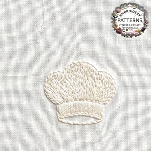 May include: A white chef hat embroidered on a white fabric background. The design features textured stitching for the hat's crown and a smooth band at the base. A circular logo in the top right corner contains the text EMBROIDERY PATTERNS STITCH & CREATE PDF DOWNLOAD.