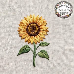 May include: A sunflower embroidery design on light beige fabric featuring a dark brown centre with yellow and orange petals, a green stem, and two green leaves. The top right corner includes a circular logo with the text EMBROIDERY PATTERNS STITCH & CREATE PDF DOWNLOAD BUY 3 GET 50% OFF.